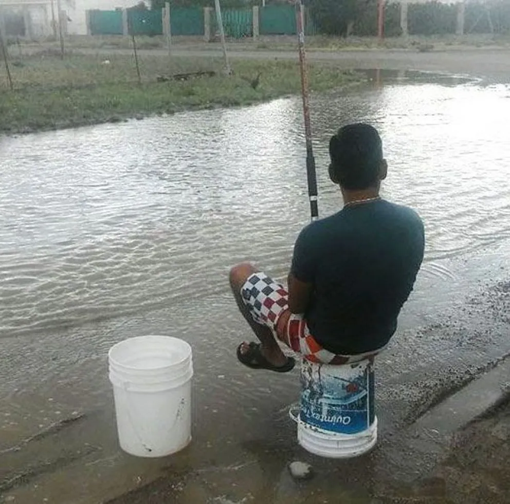 A mal tiempo, un poco de humor: vecino pesca en la calle inundada