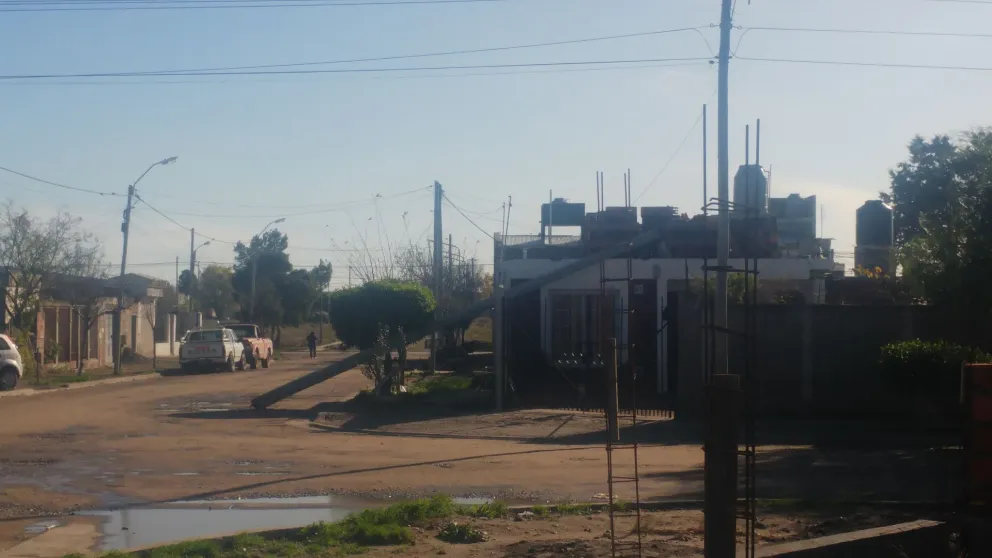 Se cayó un poste sobre el paredón de una casa