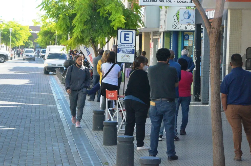 Largas colas en los comercios de cobros, un alto riesgo de contagios